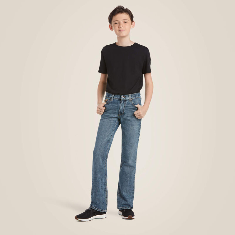 Boy's Ariat M5 slim straight jeans, in a medium wash. Full front view on model with shirt tucked.