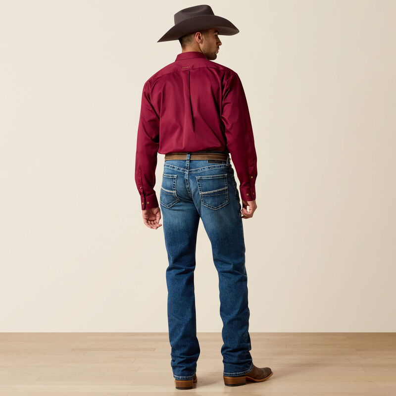 Men's Ariat M4 relaxed fit boot cut jean in a medium wash. Rear view