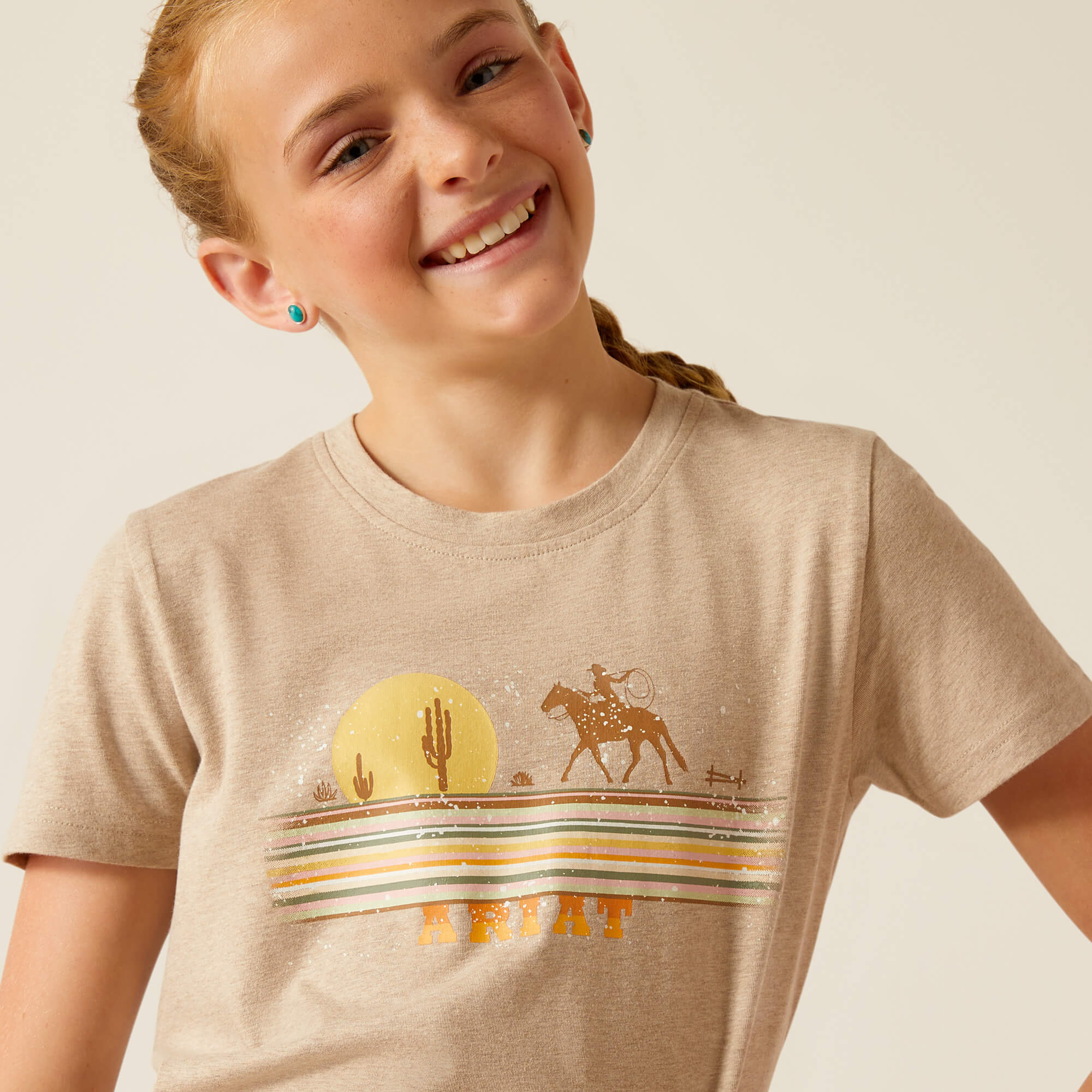 Girl's Ariat short sleeve t-shirt with a desert graphic print. Close up of chest showing graphic print.