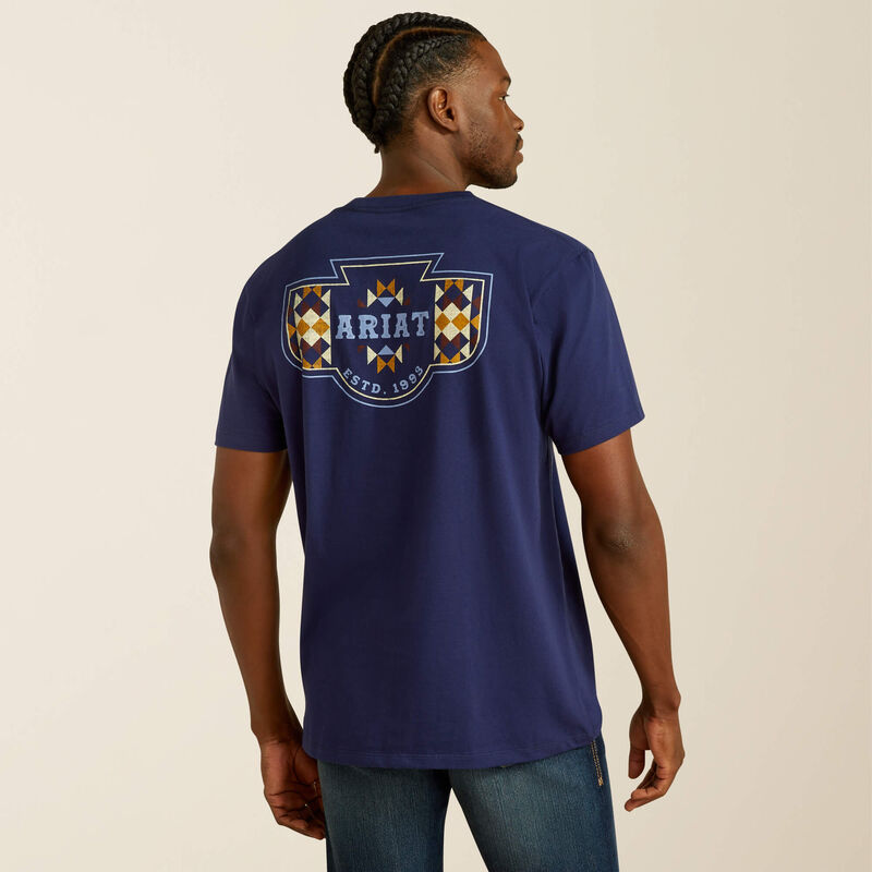 Men's Ariat logo short sleeve tee in Medieval Blue. Model is wearing shirt untucked and shows the back design.