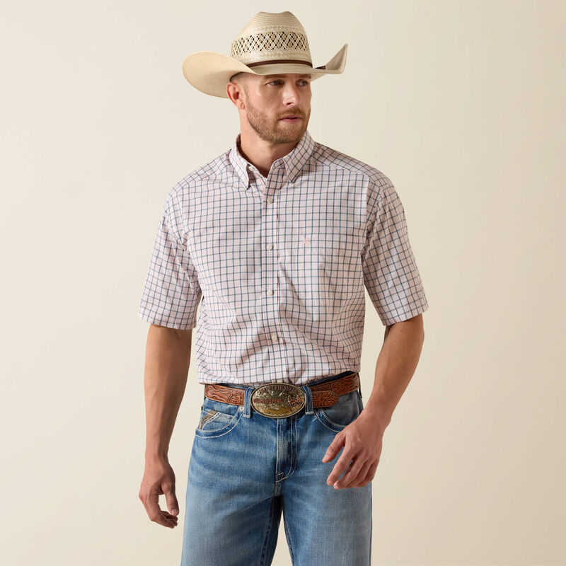 Man wearing a checkered shirt, cowboy hat, and jeans on a beige background