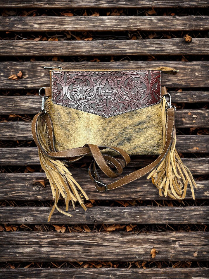 This Brown tooled leather and cowhide purse features a removable adjustable shoulder strap and a zippered closed concealed carry pocket on the rear. Inside it has six card slots and a zippered closed pocket. Front View A