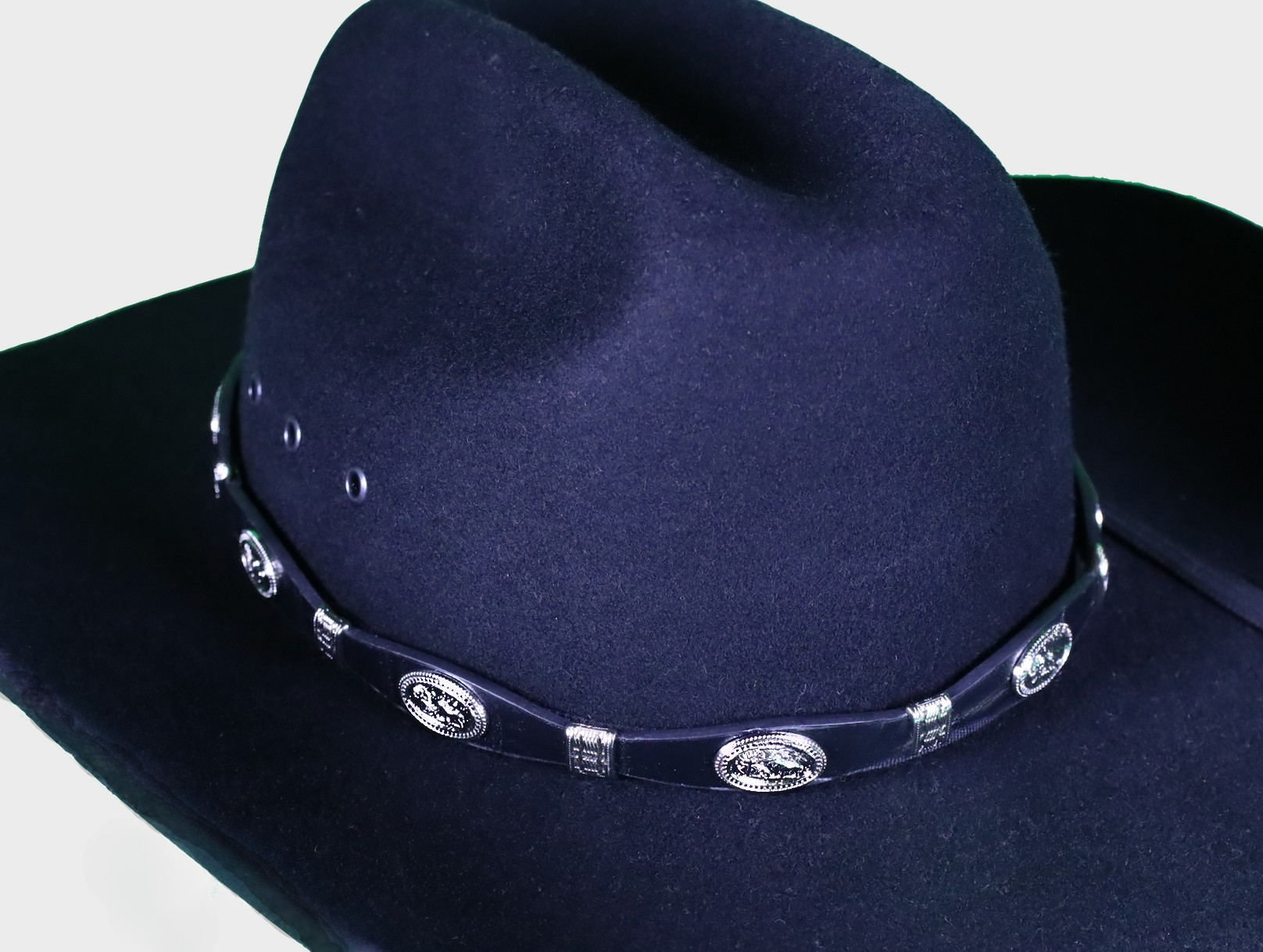 Black leather hat band with Praying Cowboy Conchos and a Western style buckle closure. Front View showing band on felt hat.