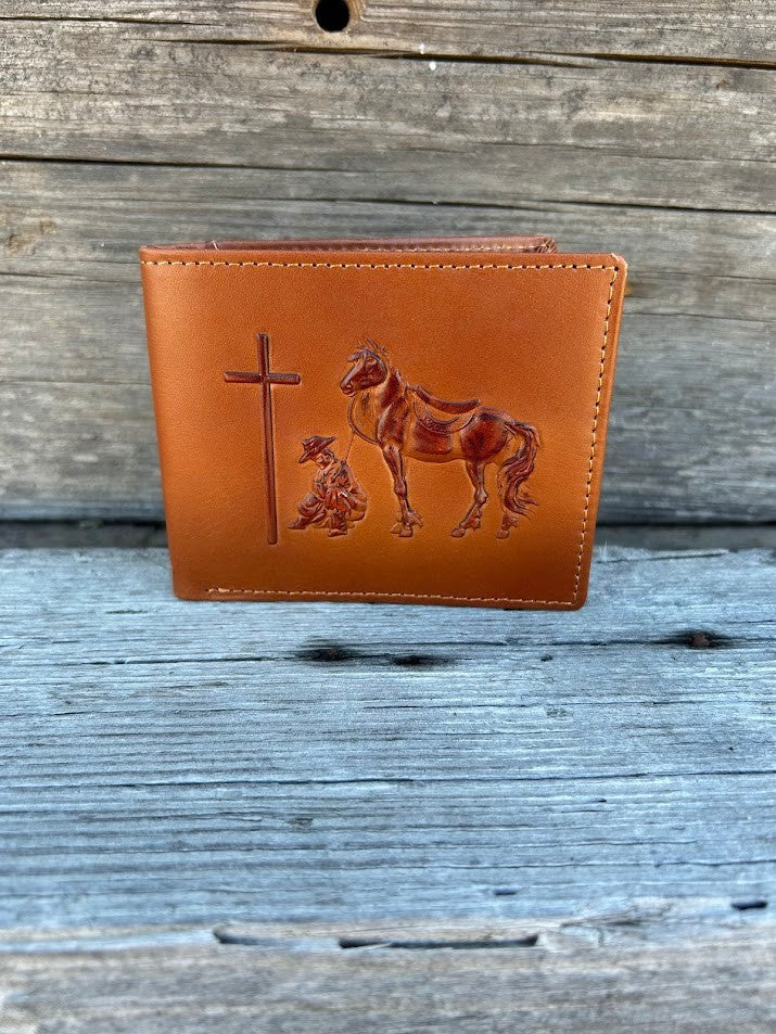 Light brown leather bifold wallet featuring a embossed Praying Cowboy design on the front. Front View