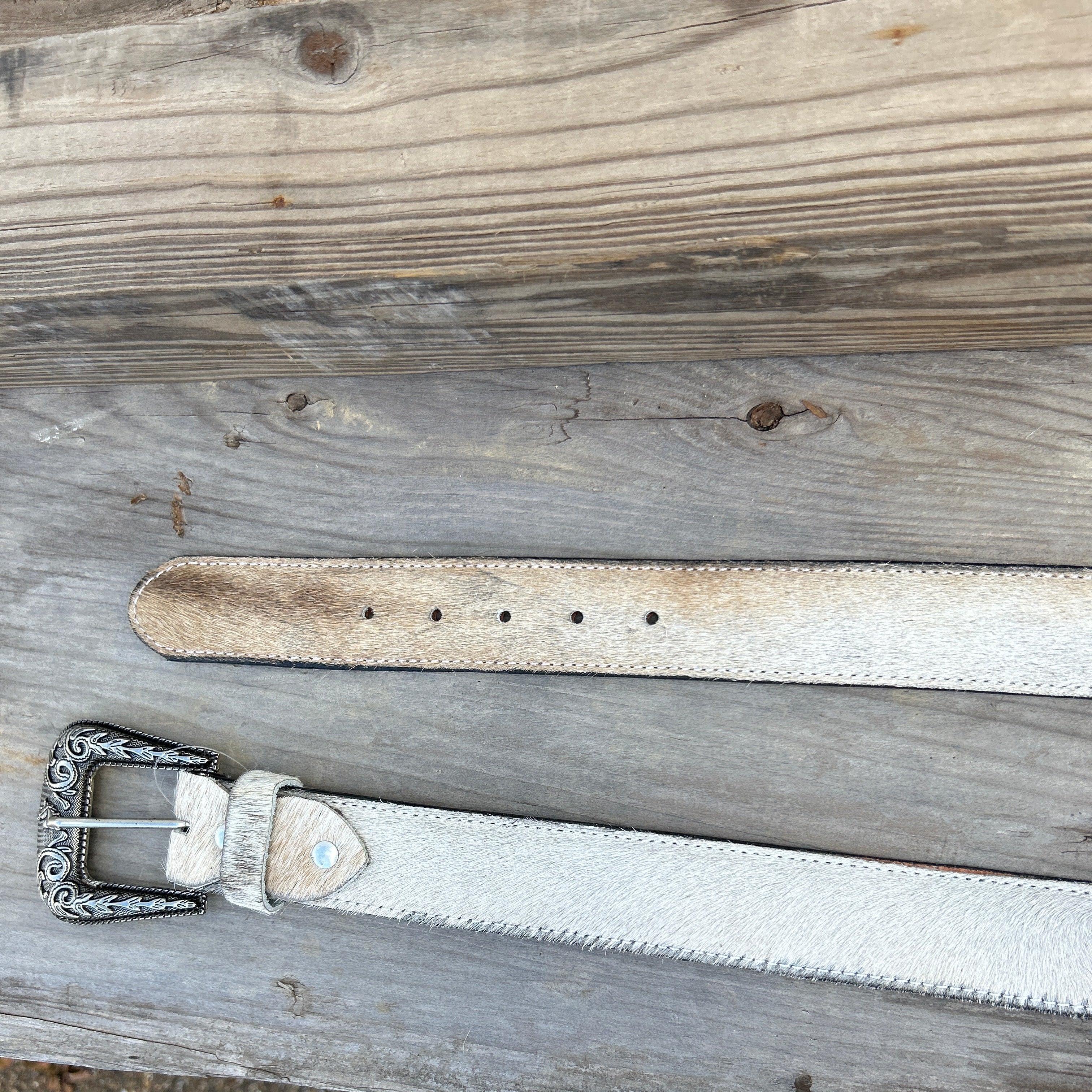 This Cowhide western style belt features a buckle with a intricate design featuring a horse. 40