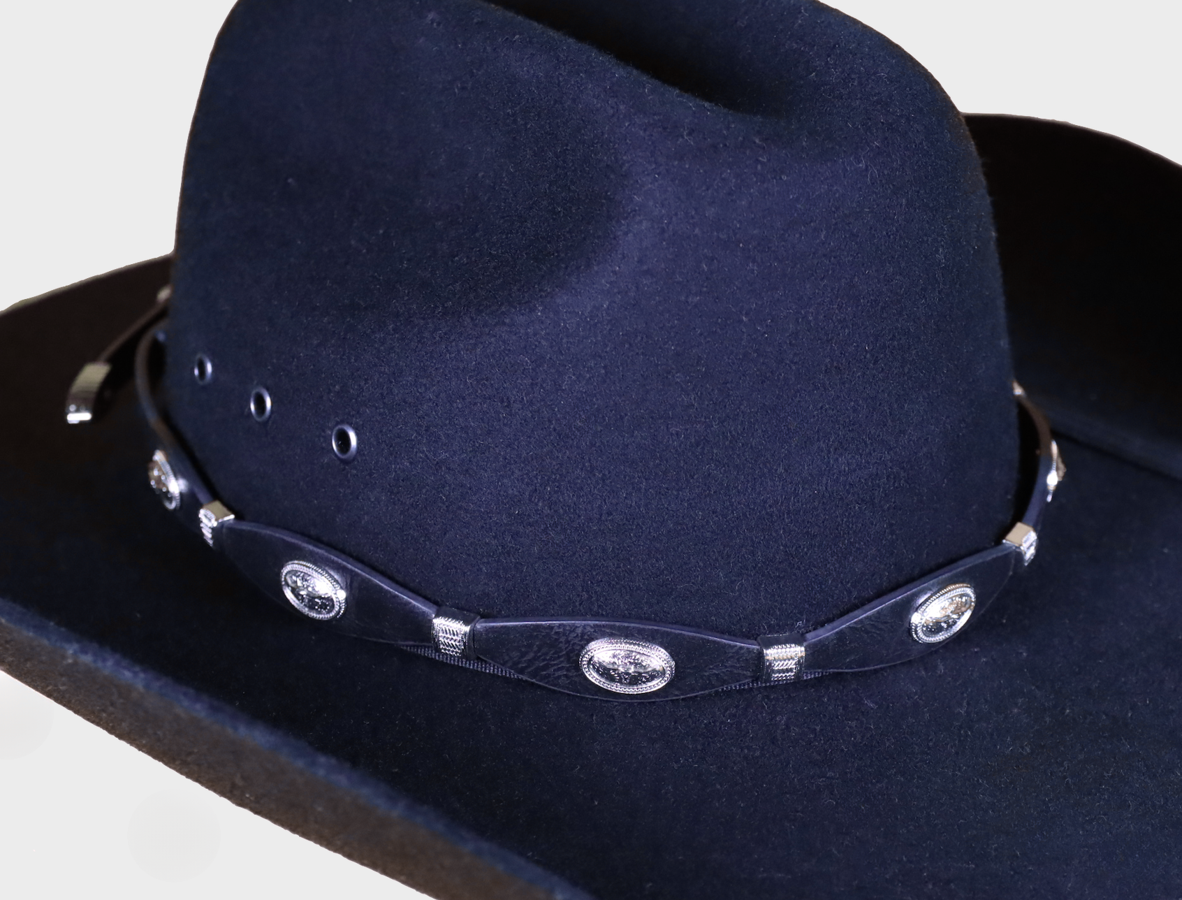 Western style Black Longhorn Concho leather hat band. Front view showing band on felt hat.