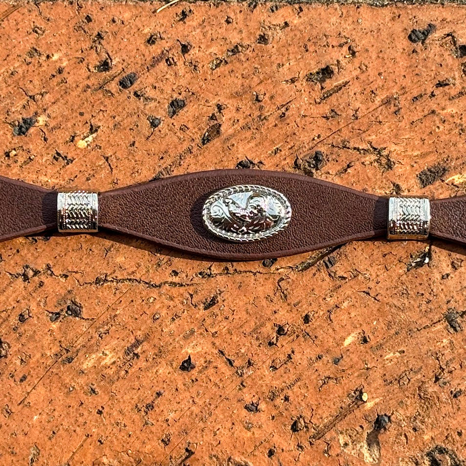 Decorative Coffee Brown leather hat band and silver buckle set and conchos on a wooden background