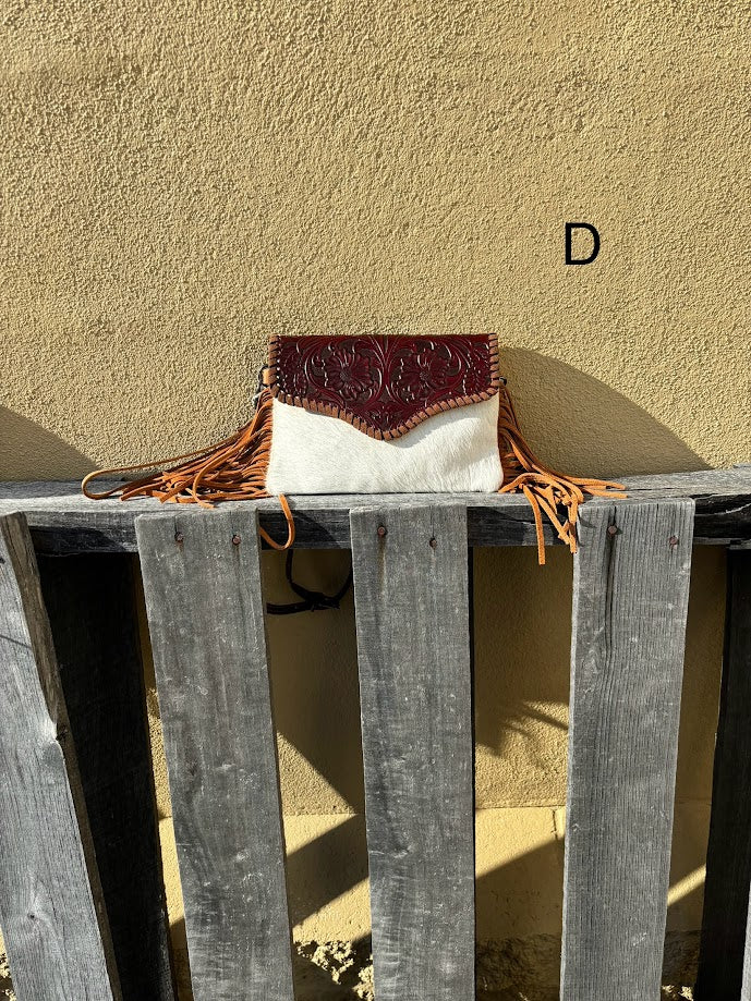 Brown tooled leather and cowhide bag with side fringe. This bag has both a wristlet and should strap. Front View D