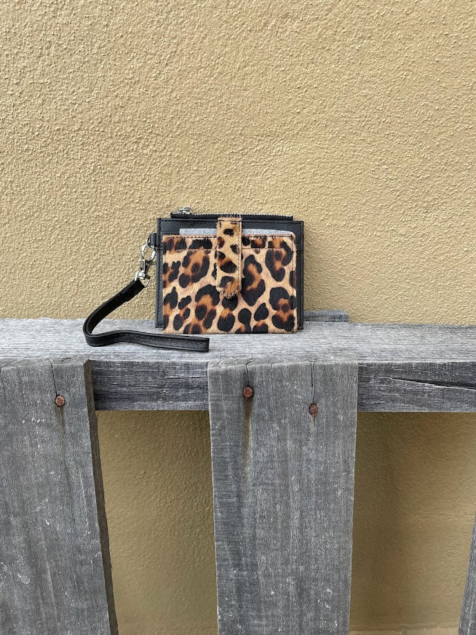 A leopard cowhide keychain wristlet wallet. Front view showing black leather wristlet.