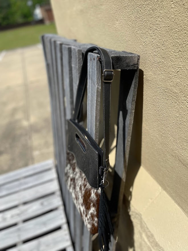 Black tooled leather and cowhide fringe bag. Side view showing purse strap.