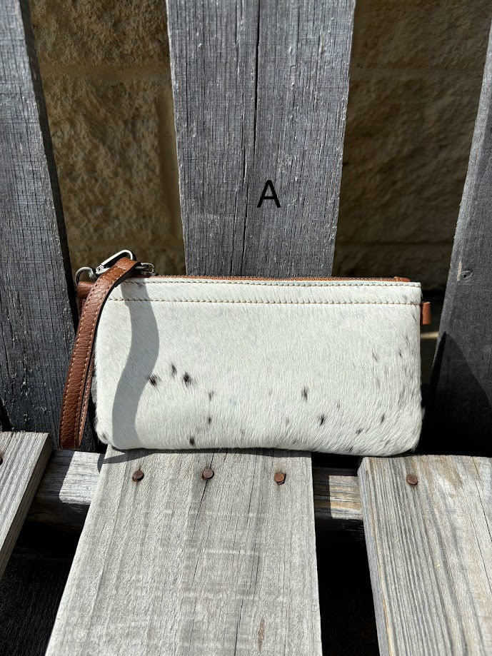 Cowhide wristlet purse with a solid Brown leather back and a zippered closure. It features a wristlet strap and and a adjustable removable shoulder strap. Front View A