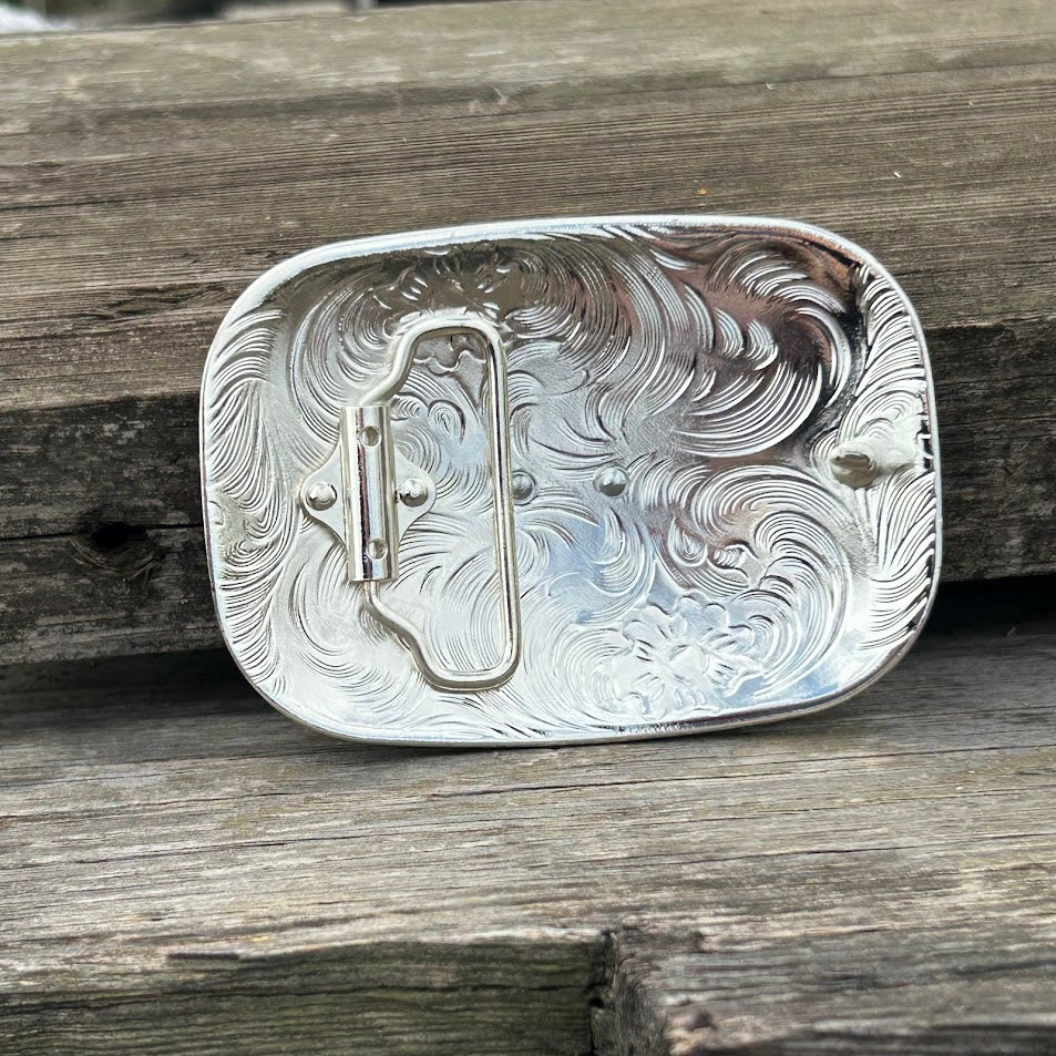 Silver rectangle belt buckle with a gold Praying Cowboy design. Buckle has a gold border with feathers. Rear View
