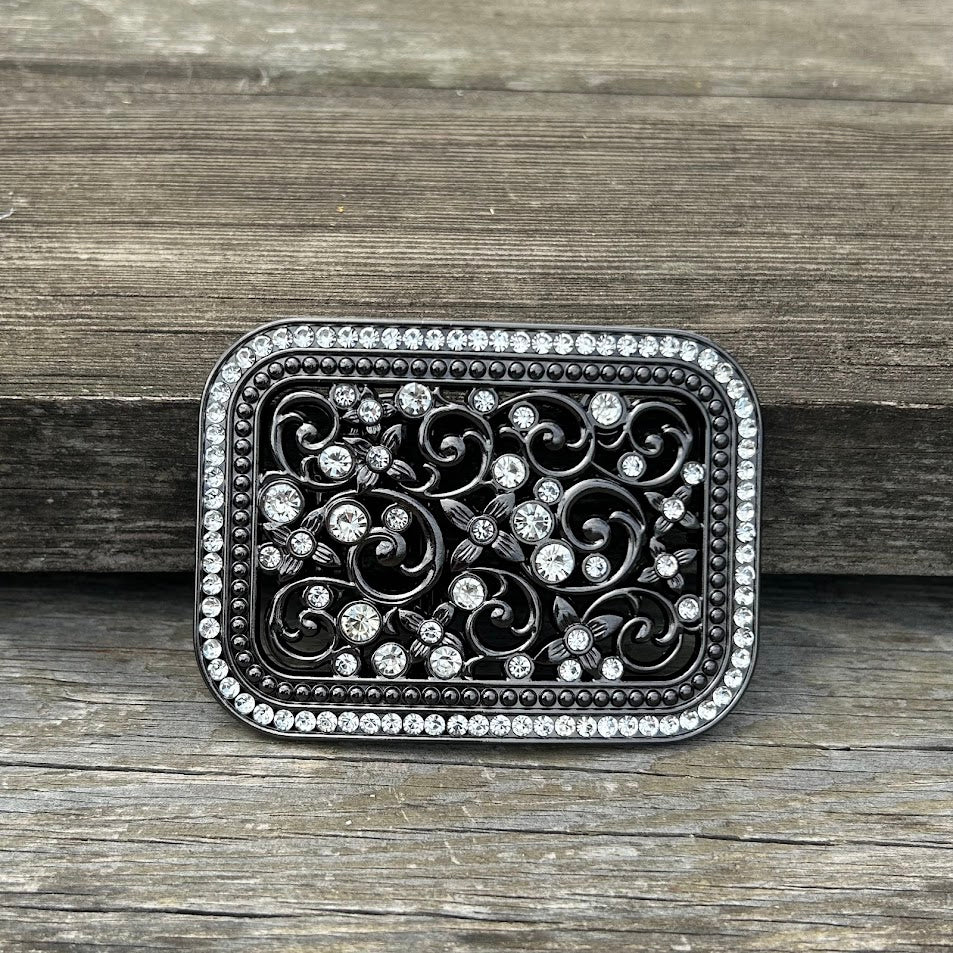 Matte Black belt buckle with floral scrollwork and rhinestones. Front View