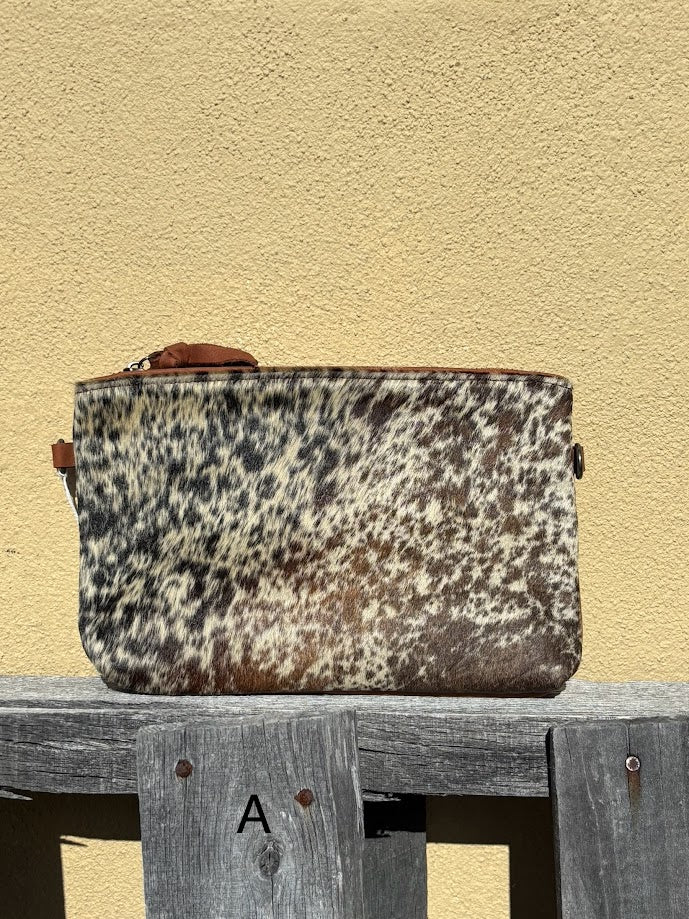 Cowhide wristlet with detachable crossbody strap with a solid Brown leather back. Front View A