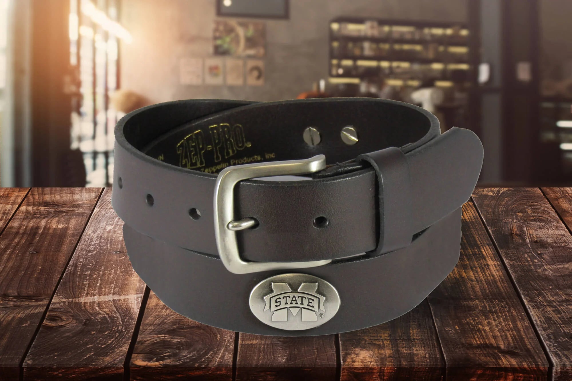 Zep-Pro kids' brown leather belt rolled up to show a silver tone metal buckle and an oval M State silver tone concho.