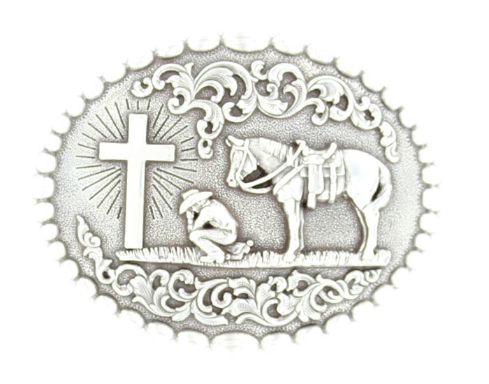 Silver tone oval western belt buckle with a beaded edge design featuring a praying cowboy and his horse near a cross.