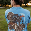 Life style photo of a young man wearing the Fieldstone Blue Comfort Color short sleeve pocket t-shirt with 4 turkey graphic print