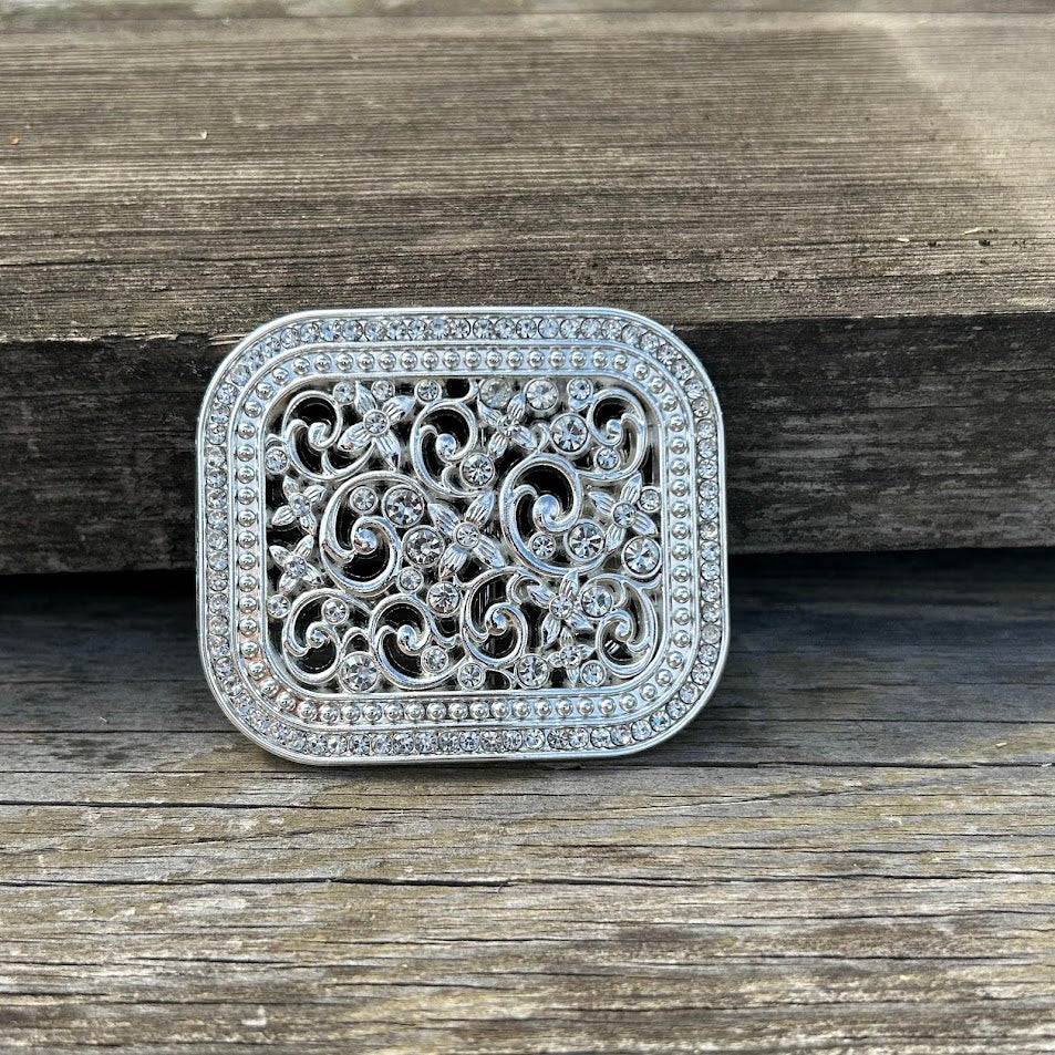 Small Silver belt buckle with rhinestones and intricate scrollwork. Front View