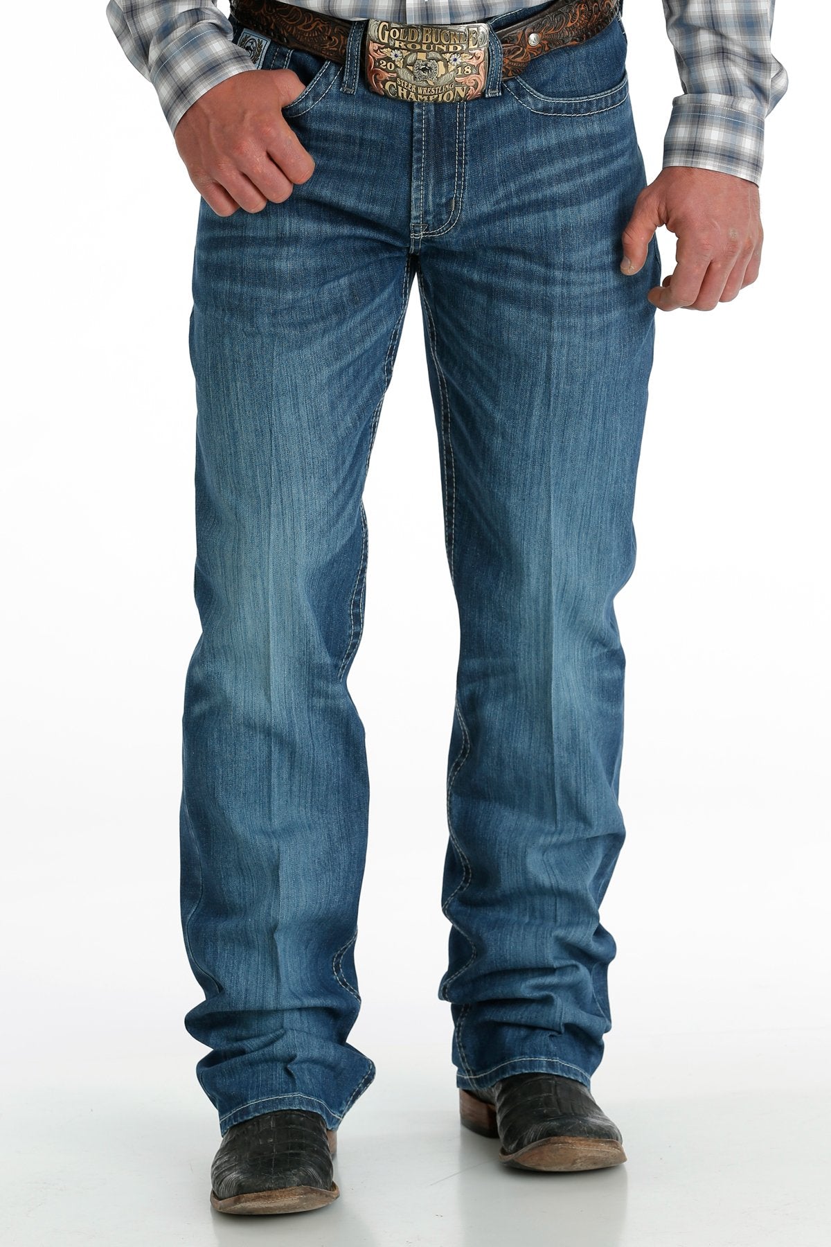 Men's White Label Medium Wash jeans front view showing detail of front pockets and zipper. Also shows relaxed fit and stack on boots.