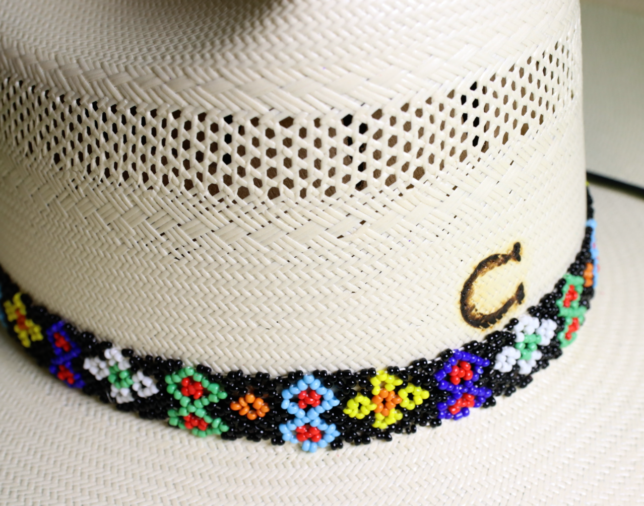 Multicolored beaded hat band featuring Yellow, Blue, Green, White, Black, Orange, and Red beads making a pattern.