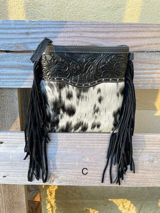 This black leather and cowhide crossbody bag has fringe details along the sides. Front View C