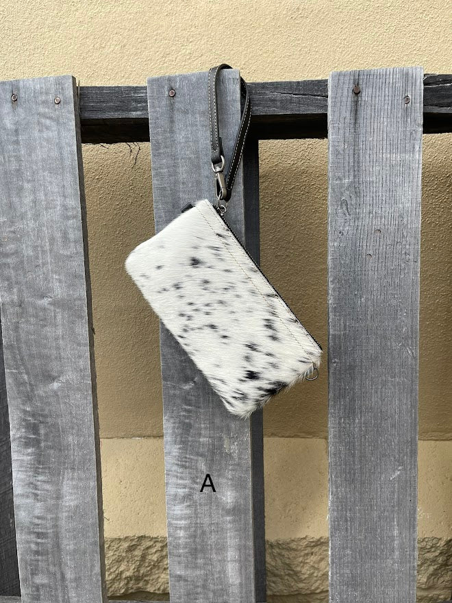 Cowhide wristlet purse in Black leather with a zippered closure. This bag has a wristlet handle or shoulder strap. Front View A