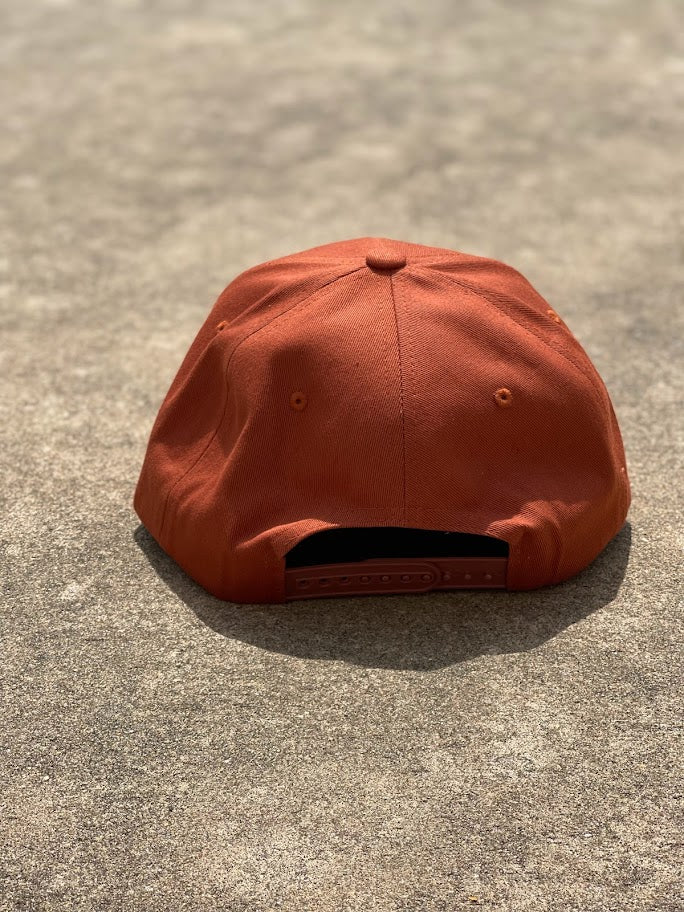 Rust snapback cap with a longhorn patch on the front. Rear View