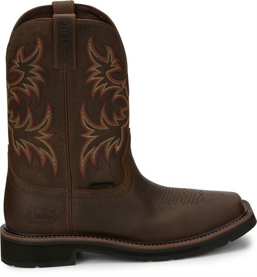 A side view pair of Justin Men's 11" Steel Toe Driller work boots in rugged tan color with a square toe style and decorative stitching.