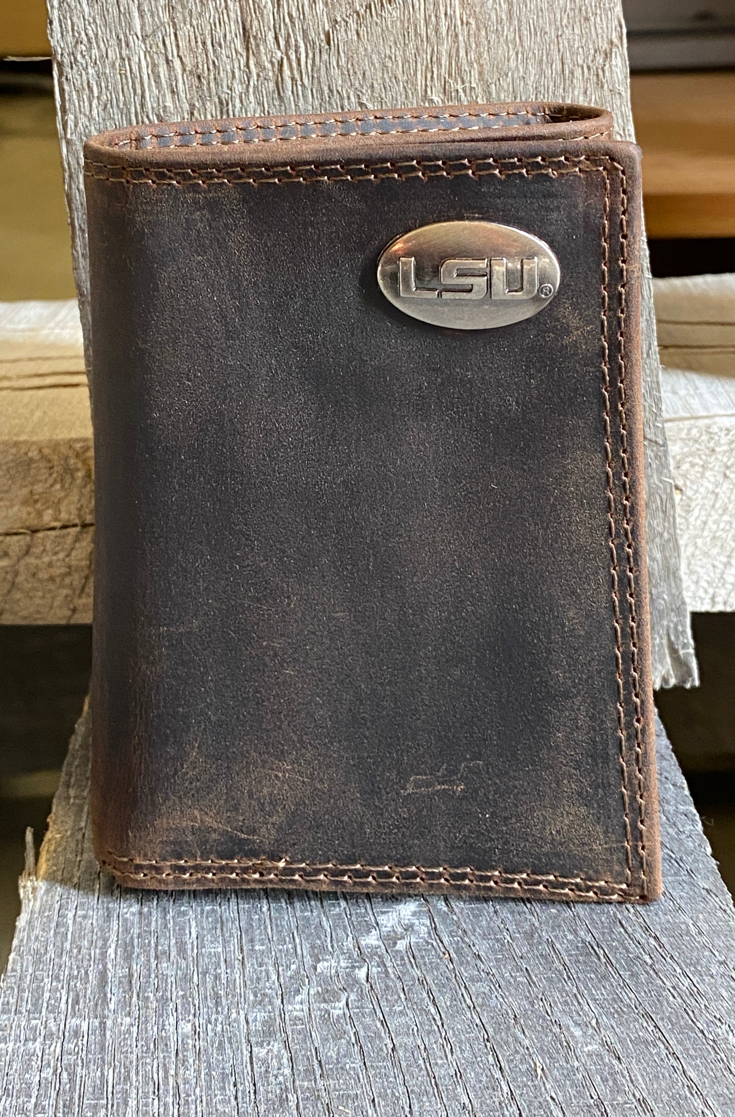 Zep-Pro LSU brown "crazy horse" leather trifold wallet with an LSU logo brass concho on the top right. Front view.
