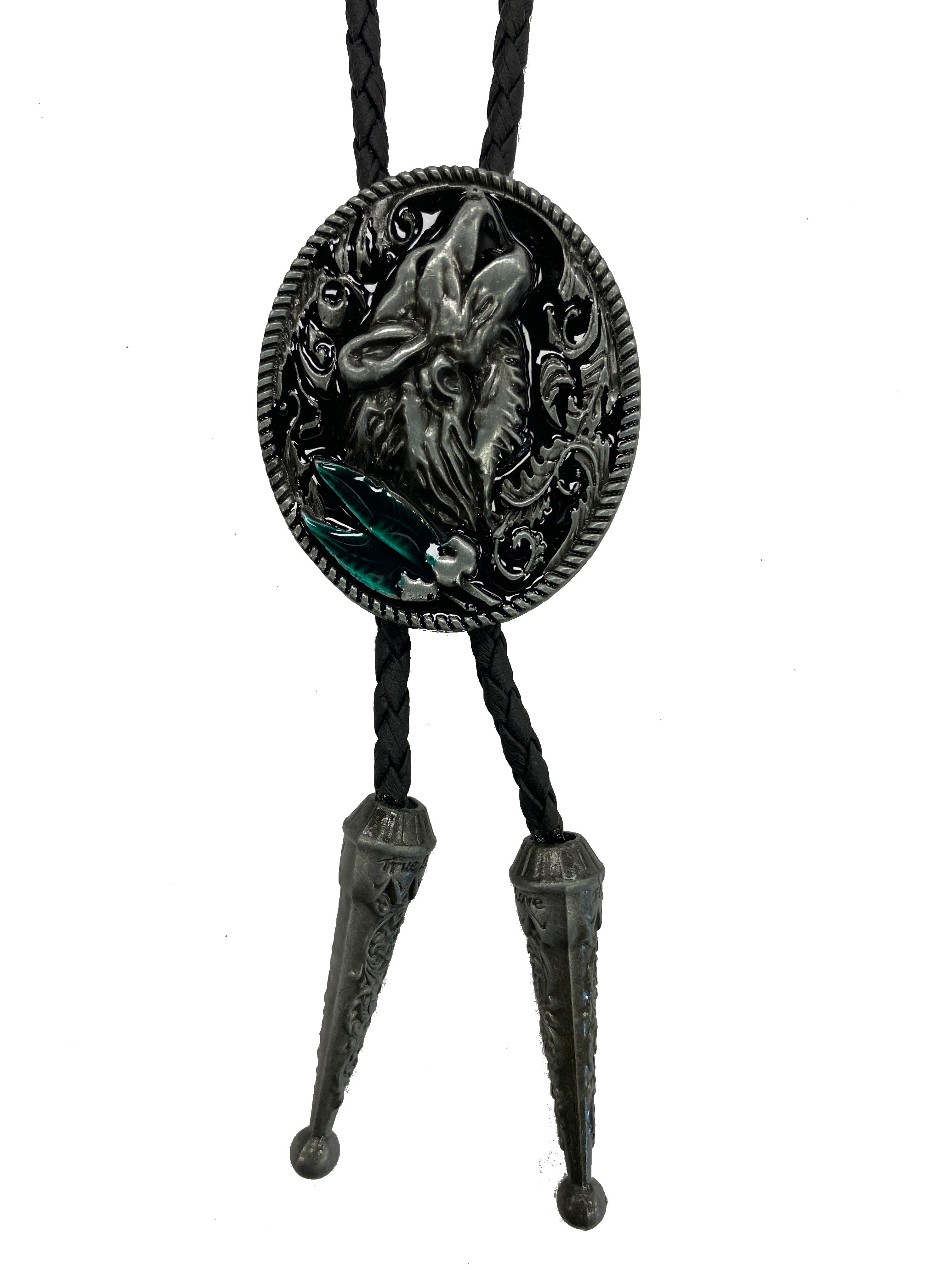 This oval shaped bolo tie features Howling Wolf design with Emerald Green colored stones. It has a black braided cord and metal tips on the end, and it is fully adjustable.