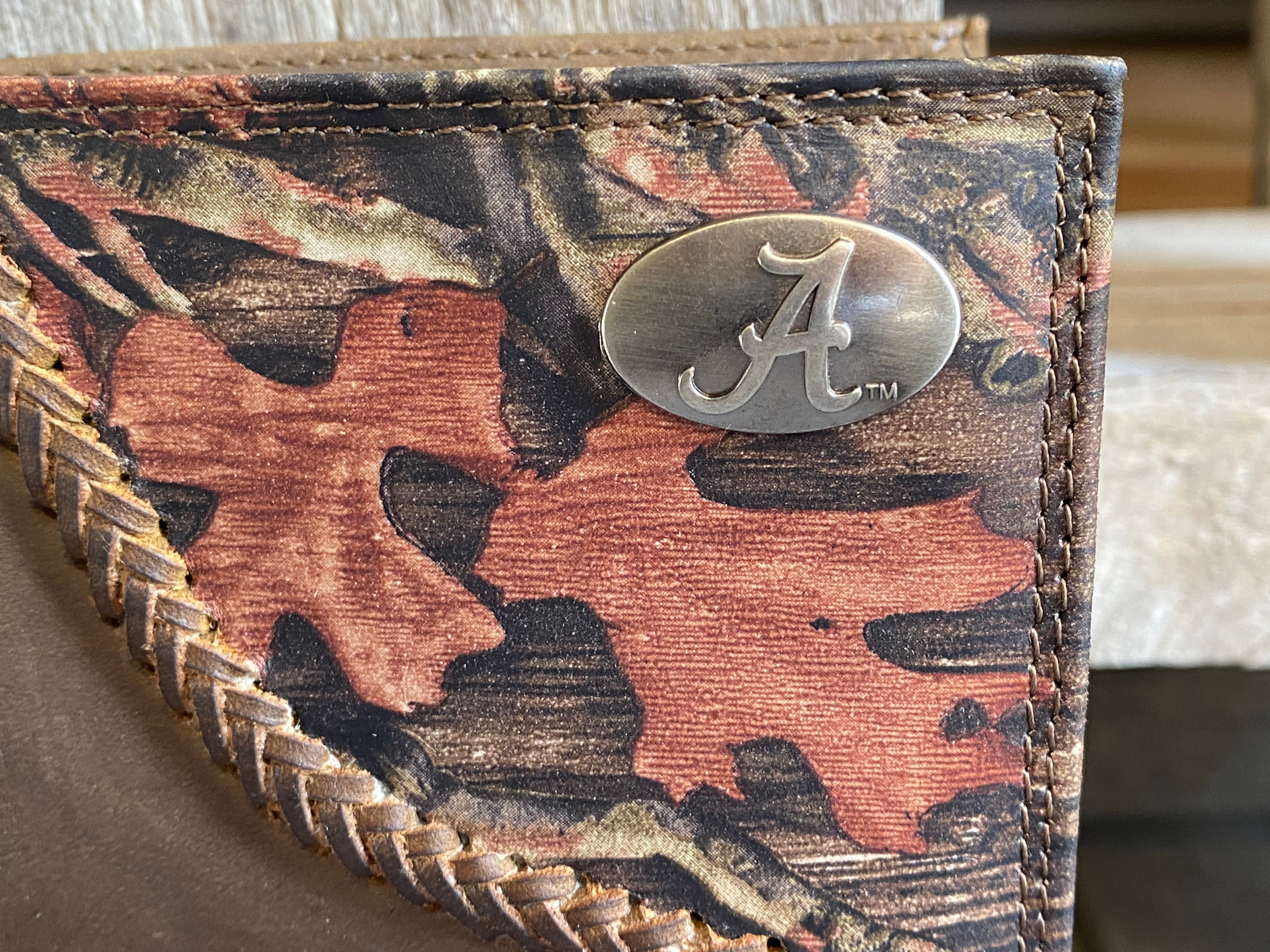 Zep-Pro University of Alabama Crimson Tide 1/2 Mossy Oak Camo/Brown Leather Bifold Wallet. Front view closeup of Alabama "A" brass concho on top right on camo leather.