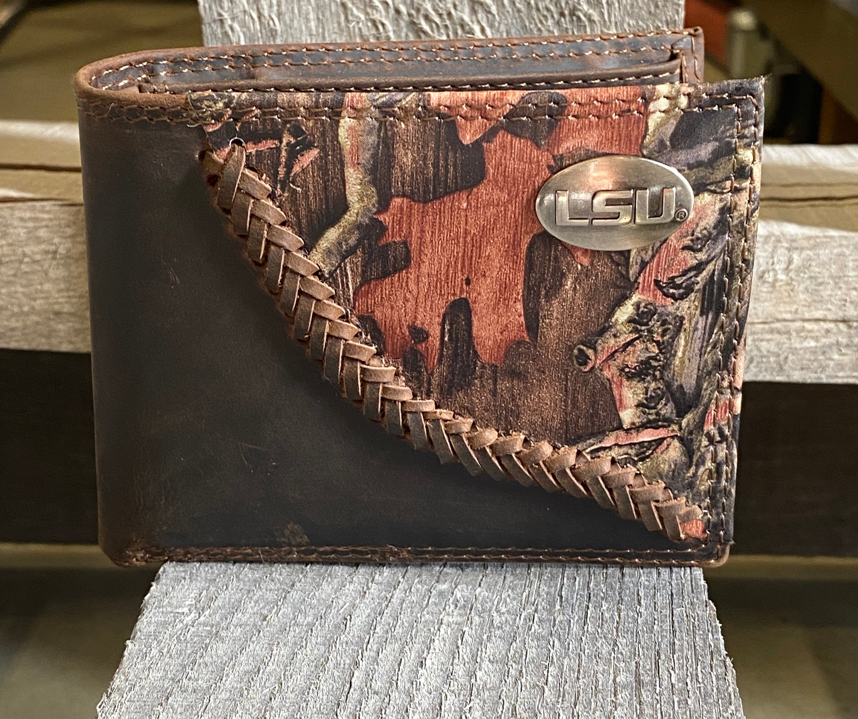 Zep-Pro Louisiana State University Tigers 1/2 Mossy Oak Camo/Brown leather Bifold Wallet. Front view features:
Crazy Horse Brown Distressed Leather
Mossy Oak Break-Up Leather Print Design
Laced “Fence-row” Border between camo and brown leather
LSU brass concho on upper right corner on camo leather