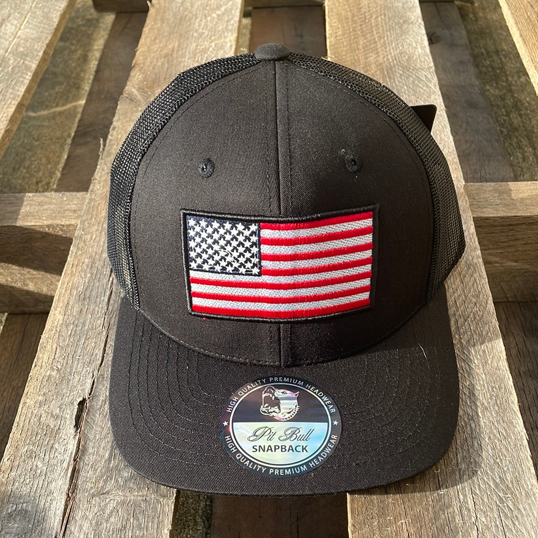 Black snapback cap with an embroidered American flag patch on the front and a mesh back. Front View
