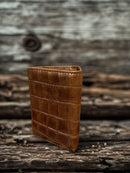Brown alligator print leather trifold wallet with a Praying Cowboy Concho on a cowhide inlay. Rear view showing a close up of the alligator print leather. 
