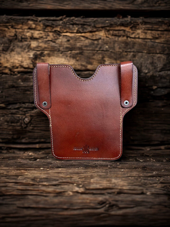 Brown leather phone case featuring a embossed Praying Cowboy design and a front pouch. Rear view showing leather belt loops. 