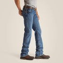 Men's Ariat Fr M4 relaxed fit boot cut jeans in a dark wash. Side view showing jeans on model. 