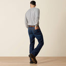 Men's Ariat FR M4 relaxed boot cut jeans in a dark wash. Rear View