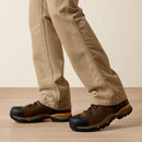 Men's Ariat FR Khaki boot cut pants. Bottom view showing leg opening over boots. 