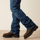 Men's Ariat M4 relaxed fit boot cut FR jeans. Bottom view showing jeans over boots. 