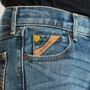 Boy's Ariat M5 slim straight jeans, in a medium wash. Close up of Ariat logo on front pocket. 
