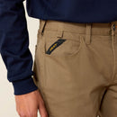 Closeup of front right with fabric closeup and hip pocket showing additional deep coin pocket. It has angled Ariat logo ribbon from side seam to top of pocket for reinforcement. Tripled stitched opening and side seam are shown on right scoop pocket. Belt loops shown are tacked with strong stitching on the top and bottom. Carabiner loop between belt loops sewn under waistband and above coin/key pocket.