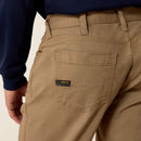 Closeup of men's Ariat khaki Rebar back left hip pocket with deep top hem that is reinforced, triple stitched sides and bottom. Has small fabric Ariat logo ribbon stitched into left side and center pocket reinforcement stitching. 