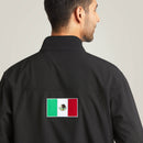 Men's Ariat softshell Team logo jacket in black with a blocked Ariat logo in white, green, and red representing the Mexican Flag. Rear view showing Mexican Flag patch. 