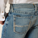 Men's Ariat M7 slim fit straight leg jeans in a light wash. Close up view of back pocket stitching details and Ariat logo tag. 
