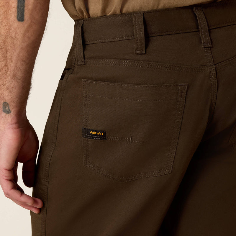 Closeup of men's Ariat wren brown Rebar back left hip pocket with deep top hem that is reinforced, triple stitched sides and bottom. Has small fabric Ariat logo ribbon stitched into left side and center pocket reinforcement stitching.
