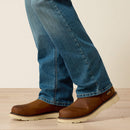Men's Ariat M5 Rebar work jeans in Edgewood, a light wash. Bottom view showing leg opening over jeans. 