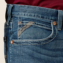 Men's Ariat M4 relaxed fit boot cut jean in a medium wash. Close up of front pocket details including a Ariat logo tag. 
