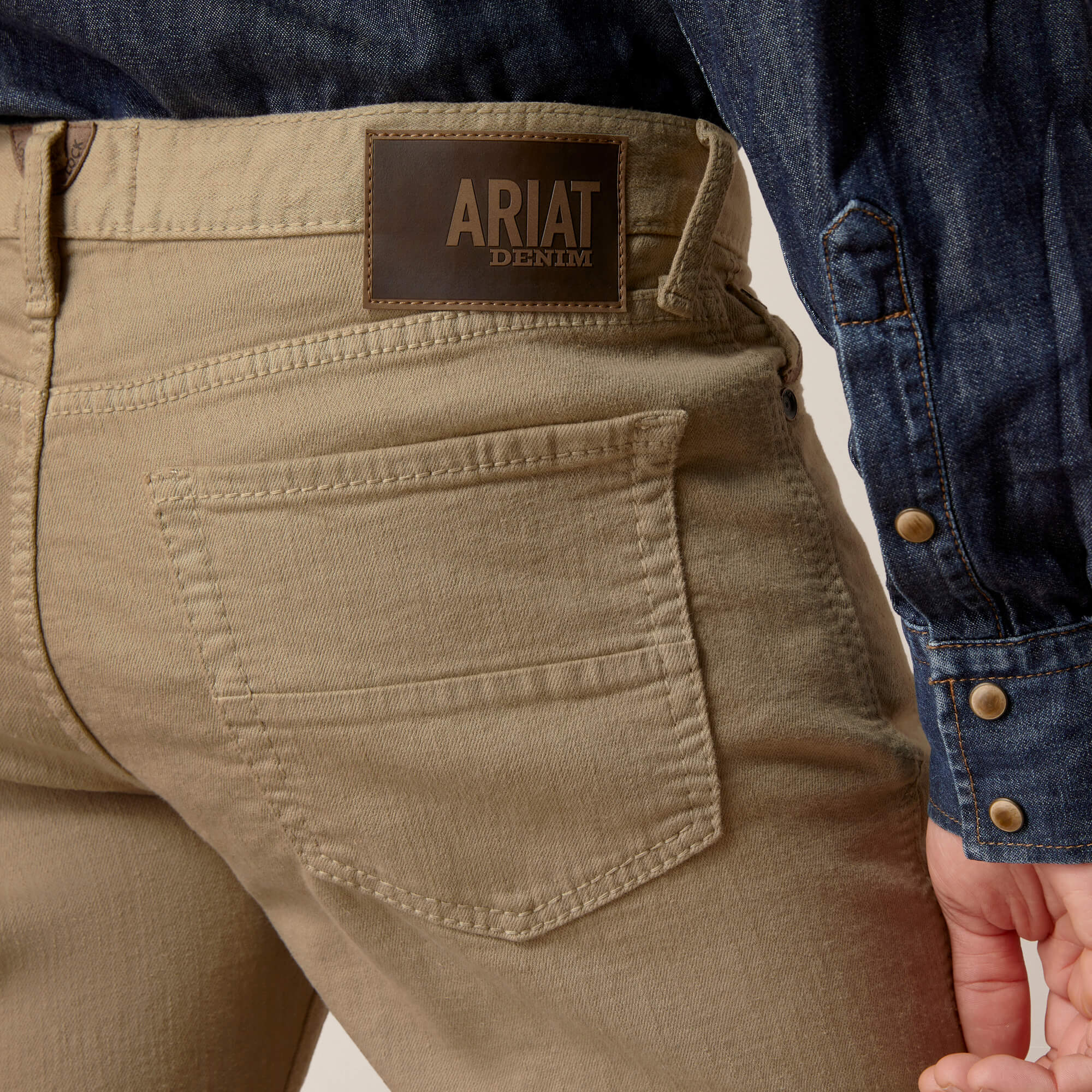 Men's Ariat M7 Straight jeans in Khaki.  Rear view close up of pocket and Ariat Denim logo patch.