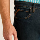 Men's Ariat M4 dark wash Pro series relaxed fit boot cut jean. Close up of front pocket showing Ariat tag logo. 
