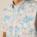 Men's Ariat short sleeve shirt in Moonbeam featuring a tropical floral cow skull pattern. This shirt is a modern fit and can be worn untucked. Close up of left chest pocket showing Ariat logo tag. 